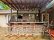 Inviting outdoor kitchen boasts a stone bar, seating, built-in grill, and ceiling fans for comfortable entertaining at 2956 Springlake Dr, Buford, GA 30519
