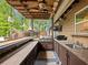 Outdoor kitchen under a covered patio featuring built-in grill and bar, provides a perfect setup for outdoor entertaining at 2956 Springlake Dr, Buford, GA 30519