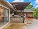 Covered outdoor kitchen with a grill, bar seating, and ample counter space is perfect for hosting gatherings at 2956 Springlake Dr, Buford, GA 30519