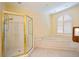 Bright bathroom featuring a glass shower, soaking tub, and plantation shutters at 4070 Ridgehurst Se Dr, Smyrna, GA 30080