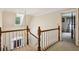 Upstairs hallway with wood banister, chandelier, and bedroom entrance at 4070 Ridgehurst Se Dr, Smyrna, GA 30080