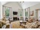 Spacious living room with a fireplace, cathedral ceiling, neutral colors, and large windows at 4070 Ridgehurst Se Dr, Smyrna, GA 30080