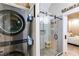 Beautiful bathroom with a stacked washer/dryer and glass-enclosed shower at 5200 Woodmont Dr, Villa Rica, GA 30180