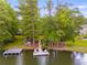 Waterfront view of a private dock featuring chairs, swing, and a picnic table, perfect for outdoor enjoyment at 5200 Woodmont Dr, Villa Rica, GA 30180