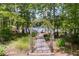 Beautiful view of the lake and dock through a decorative archway surrounded by lush greenery at 5200 Woodmont Dr, Villa Rica, GA 30180