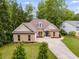 Charming brick home featuring a well-manicured lawn, a dormer window, and a long driveway at 5200 Woodmont Dr, Villa Rica, GA 30180