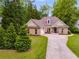 Attractive brick home with a long driveway, lush lawn, and mature trees at 5200 Woodmont Dr, Villa Rica, GA 30180