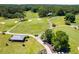 Aerial view featuring lush golf course, cart paths, sand traps, and clubhouse at 5200 Woodmont Dr, Villa Rica, GA 30180