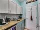 Mud room with tile backsplash, utility sink, mini refrigerator, and access to backyard at 5200 Woodmont Dr, Villa Rica, GA 30180