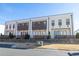 Modern townhomes showcase a crisp white facade with dark accents and a wooden fence at 896 Farmstead Rd # 162, Suwanee, GA 30024
