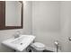 Small powder room featuring pedestal sink with framed mirror and ceramic toilet at 896 Farmstead Rd # 162, Suwanee, GA 30024