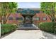 Exterior view of a vintage brick building entrance featuring manicured landscaping and an awning at 91 Rumson Ne Rd # B25, Atlanta, GA 30305