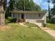 Home exterior featuring a grey brick facade, small front porch, and attached garage at 115 Delmoor Nw Dr, Atlanta, GA 30311