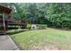 Landscaped backyard featuring a wooden deck, an above-ground pool, and mature trees at 128 Champion Way, Hiram, GA 30141