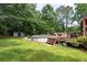 Landscaped backyard featuring a wooden deck, an above-ground pool, and mature trees at 128 Champion Way, Hiram, GA 30141