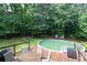 Backyard with an above ground pool and deck with chairs, surrounded by mature trees offering a private outdoor retreat at 128 Champion Way, Hiram, GA 30141