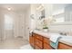 Bright bathroom with double sinks, wooden cabinets, decorative mirrors, and tile floor at 128 Champion Way, Hiram, GA 30141