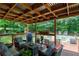 This covered deck offers comfortable seating, a grill, and a view of the pool, perfect for outdoor entertaining at 128 Champion Way, Hiram, GA 30141