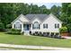 Charming single-story home with a well-manicured lawn, complemented by beautiful landscaping, enhancing its curb appeal at 128 Champion Way, Hiram, GA 30141