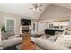 Comfortable living room with stone fireplace, hardwood floors, and a seamless transition to the modern kitchen at 128 Champion Way, Hiram, GA 30141