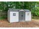 Backyard shed with grey doors and white trim and surrounding greenery at 128 Champion Way, Hiram, GA 30141