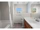 Bathroom featuring a shower-tub combo, vanity, toilet, and large window at 2540 Park Ave, Austell, GA 30106