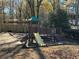 A wooden playground with a slide and swings sits on a mulch bed, perfect for Gathering fun at 2540 Park Ave, Austell, GA 30106