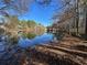A serene pond reflects the surrounding trees on a clear day, enhancing the natural beauty of the property at 2540 Park Ave, Austell, GA 30106