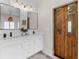 Bright bathroom featuring a double vanity with marble counters, modern fixtures, and unique sliding wood doors at 31 Copper Leaf Ct, Villa Rica, GA 30180