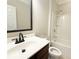 Traditional bathroom features a dark wood vanity, framed mirror, and shower over tub at 139 Vinca Cir, Suwanee, GA 30024