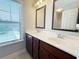 Bathroom featuring double sinks, dark cabinets, and framed mirrors with natural light at 139 Vinca Cir, Suwanee, GA 30024