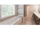 Bright bathroom featuring a soaking tub, a large window, and updated tile at 139 Vinca Cir, Suwanee, GA 30024