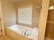 Soaking tub with tile surround and decorative fixtures located inside the primary bathroom at 139 Vinca Cir, Suwanee, GA 30024