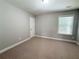 Neutral bedroom with a window and carpeted floor; room features neutral paint at 139 Vinca Cir, Suwanee, GA 30024