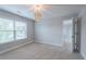 Carpeted bedroom featuring modern lighting, a window, and grey walls at 139 Vinca Cir, Suwanee, GA 30024
