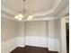 Dining room with wainscotting, hardwood floors, crown molding, and modern chandelier lighting at 139 Vinca Cir, Suwanee, GA 30024