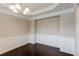 A dining room featuring elegant wainscoting, a modern chandelier, and dark hardwood floors at 139 Vinca Cir, Suwanee, GA 30024