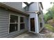 Exterior side view of the house featuring gray siding, windows, and a glass door leading to the backyard at 139 Vinca Cir, Suwanee, GA 30024