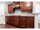 Updated kitchen with dark wood cabinets, stone backsplash, and stainless gas range at 139 Vinca Cir, Suwanee, GA 30024