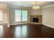 Bright living room featuring a stone fireplace, hardwood floors, and a large window with natural light at 139 Vinca Cir, Suwanee, GA 30024