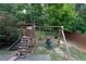 Backyard with a wooden playset including a slide, swings, and climbing area for enjoyment at 139 Vinca Cir, Suwanee, GA 30024