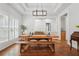 Bright dining room featuring hardwood floors, farmhouse table, modern lighting fixture at 2945 Ashbyrn Ct, Buford, GA 30519