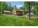 Large backyard with mature trees, green grass, a large home and several outbuildings at 2945 Ashbyrn Ct, Buford, GA 30519