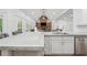 Bright, open kitchen featuring an island with concrete countertops and a stone fireplace in the background at 2945 Ashbyrn Ct, Buford, GA 30519