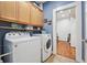 Laundry room with washer, dryer, cabinets, and storage shelves at 2945 Ashbyrn Ct, Buford, GA 30519