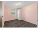 Cozy bedroom with wood-look flooring, a window, and painted pink walls at 315 Pleasant Grove Rd, Mcdonough, GA 30252