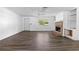 Spacious living room with a brick fireplace, large window, and modern wood-look flooring at 315 Pleasant Grove Rd, Mcdonough, GA 30252