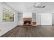 Inviting living room featuring a brick fireplace, built-in shelves, and large windows at 315 Pleasant Grove Rd, Mcdonough, GA 30252