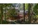 Rear view of home with sunroom addition and a charming deck overlooking lush landscaping and mature trees at 3287 Alton Rd, Atlanta, GA 30341