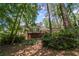 Rear view of home with sunroom addition and a charming deck overlooking lush landscaping and mature trees at 3287 Alton Rd, Atlanta, GA 30341